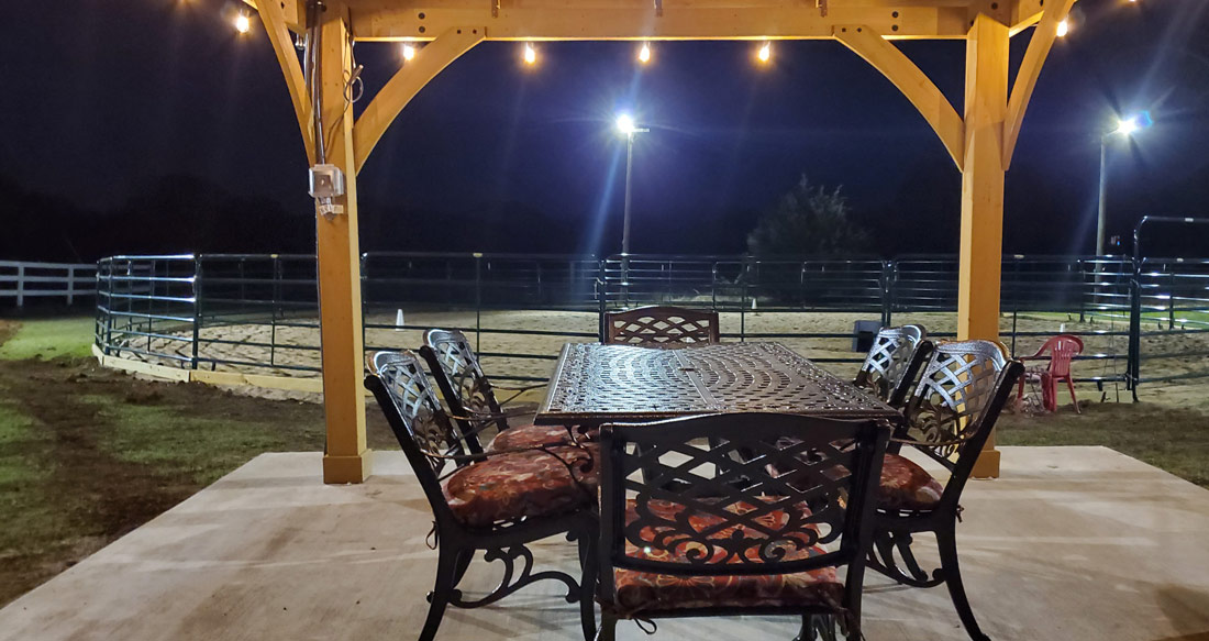 closeup of table under gazebo, roundpen behind it